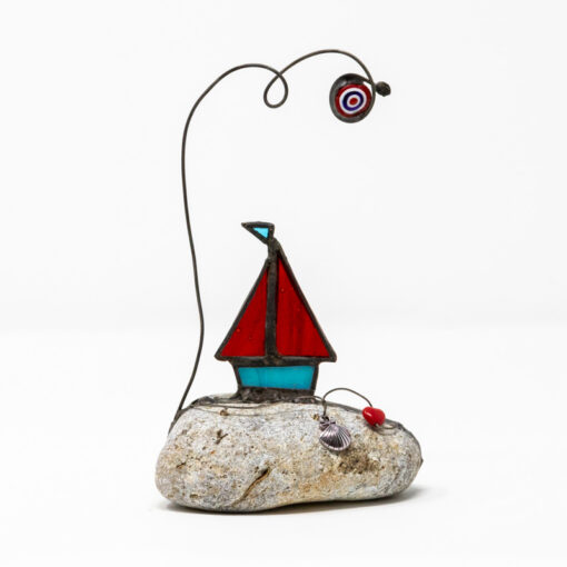 Sailing boat on rock red sails