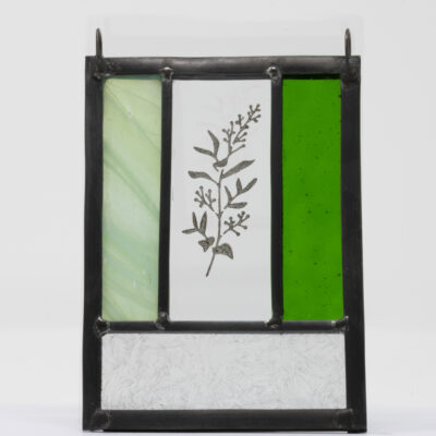Mini, traditionally made stained glass panel with green glass rectangles and clear textured rectangles and a delicate design of foliage in glass paint in the centre.